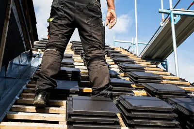 Man roofing new, black stones